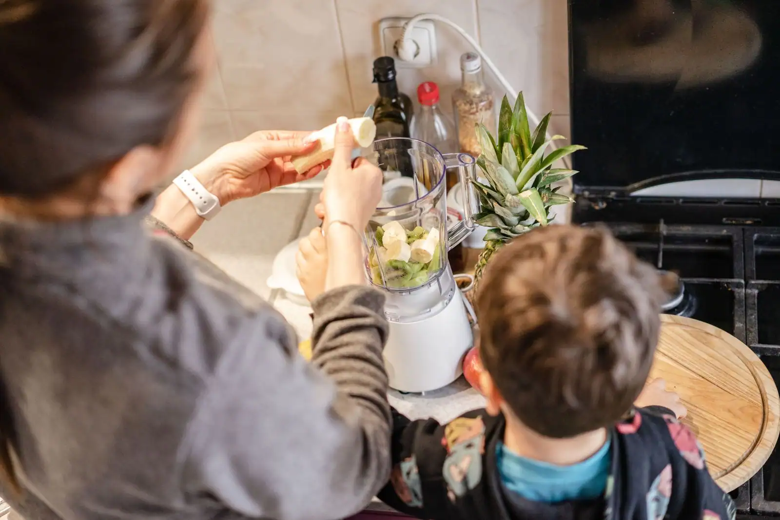 Blender à bol rempli de fruits pour préparer un smoothie sur un plan de travail de cuisine