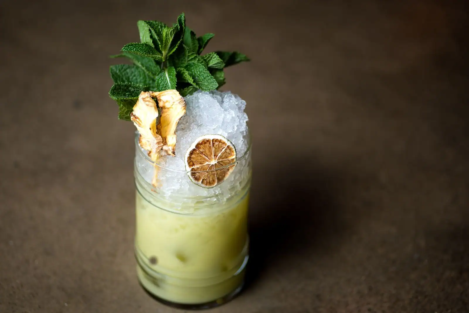 Cocktail aux agrumes et à la menthe, glace pilée et garniture dans un verre haut