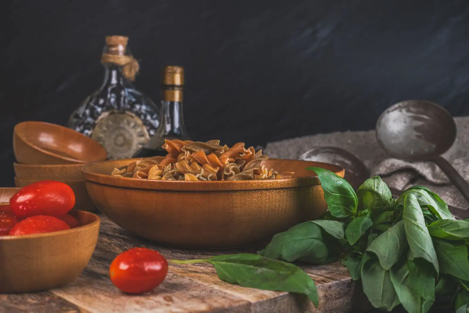 Ingrédients de cuisine italienne sur une table : pâtes, tomates, huile d'olive et basilic frais