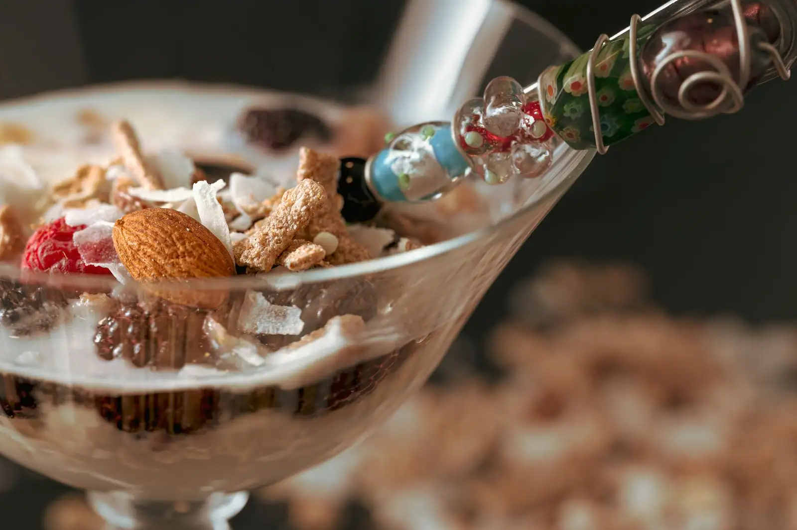 Verrine de dessert avec laitier, céréales, copeaux de coco, une amande et un fruit rouge