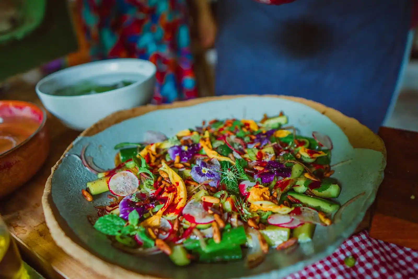Entrée fraîche et colorée à l'assiette avec concombre, radis, graines et fleurs comestibles