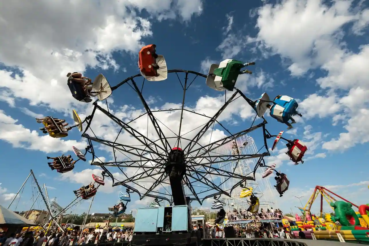 Manège à chaises volantes et attractions d'un parc d'attractions sous un ciel bleu