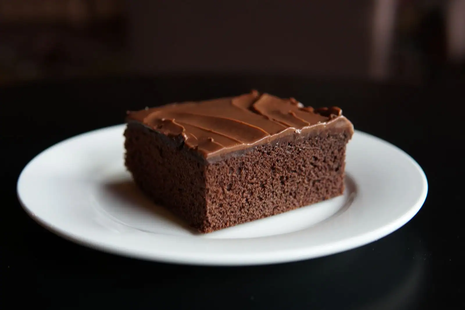 Part de gâteau au chocolat moelleux et fondant, servie sur une petite assiette blanche