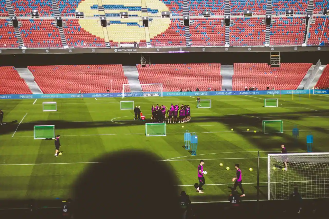 Seance d'entrainement de football sur la pelouse d'un grand stade aux tribunes presque vides