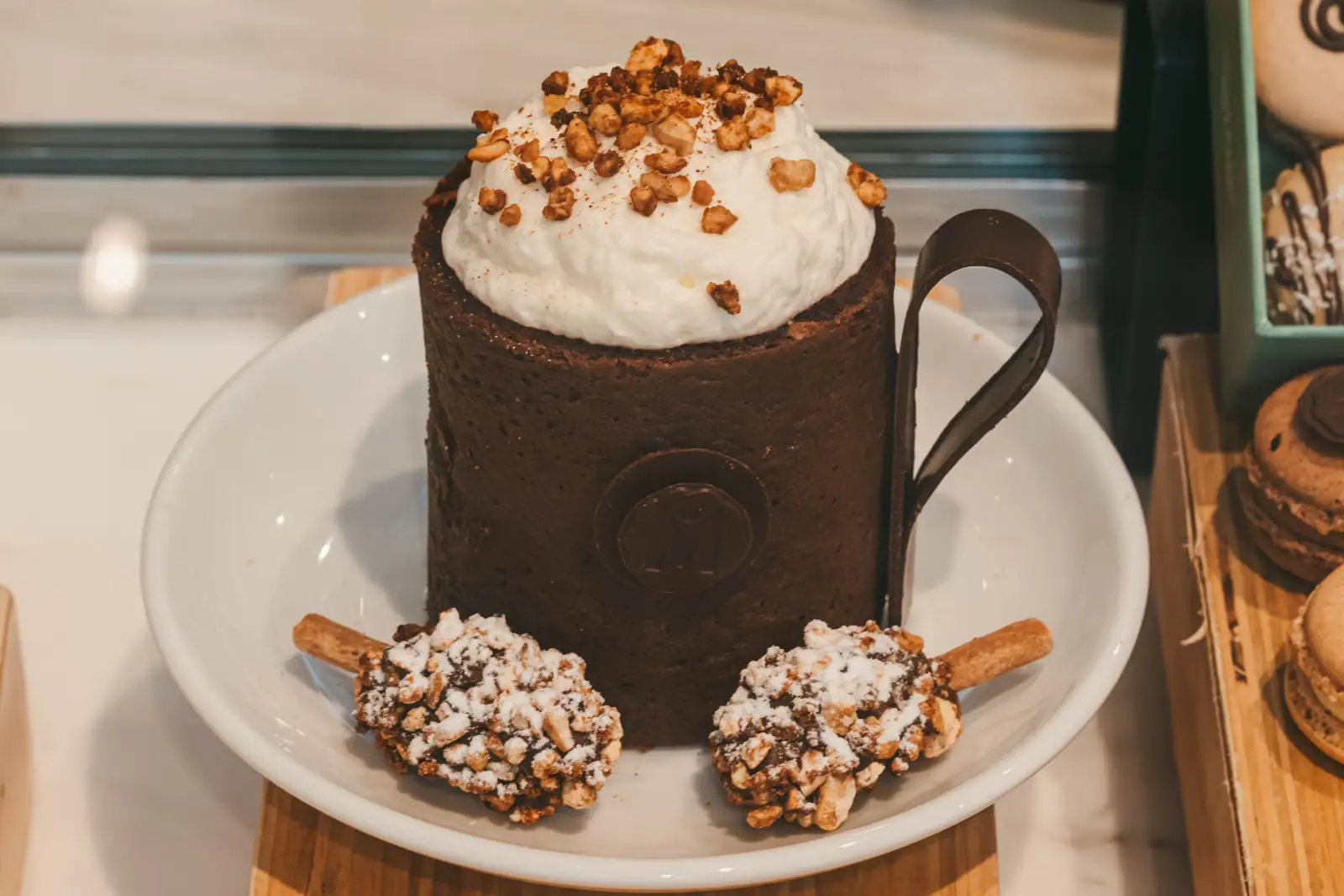 Mug cake au chocolat surmonté de crème fouettée et d'éclats de noisettes dans une tasse