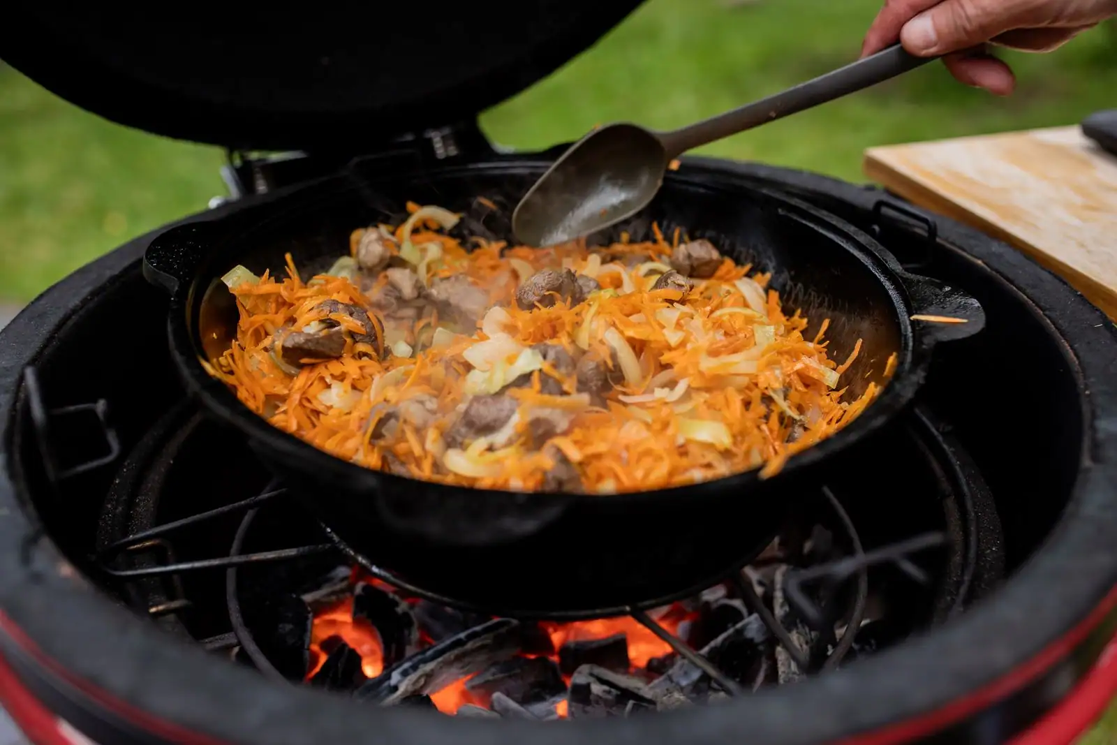 Mijoté de viande, carottes et oignons dans une cocotte en fonte cuit doucement sur des braises