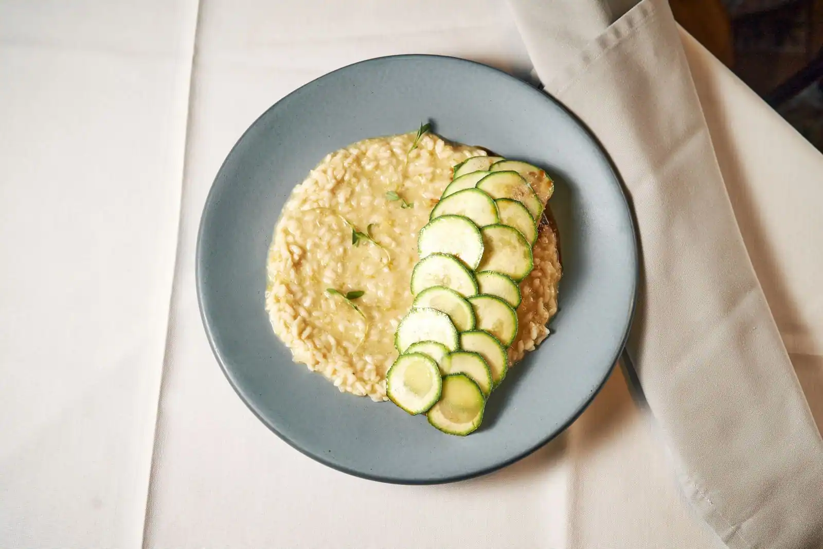 Assiette de risotto crémeux à la courgette parsemé de parmesan