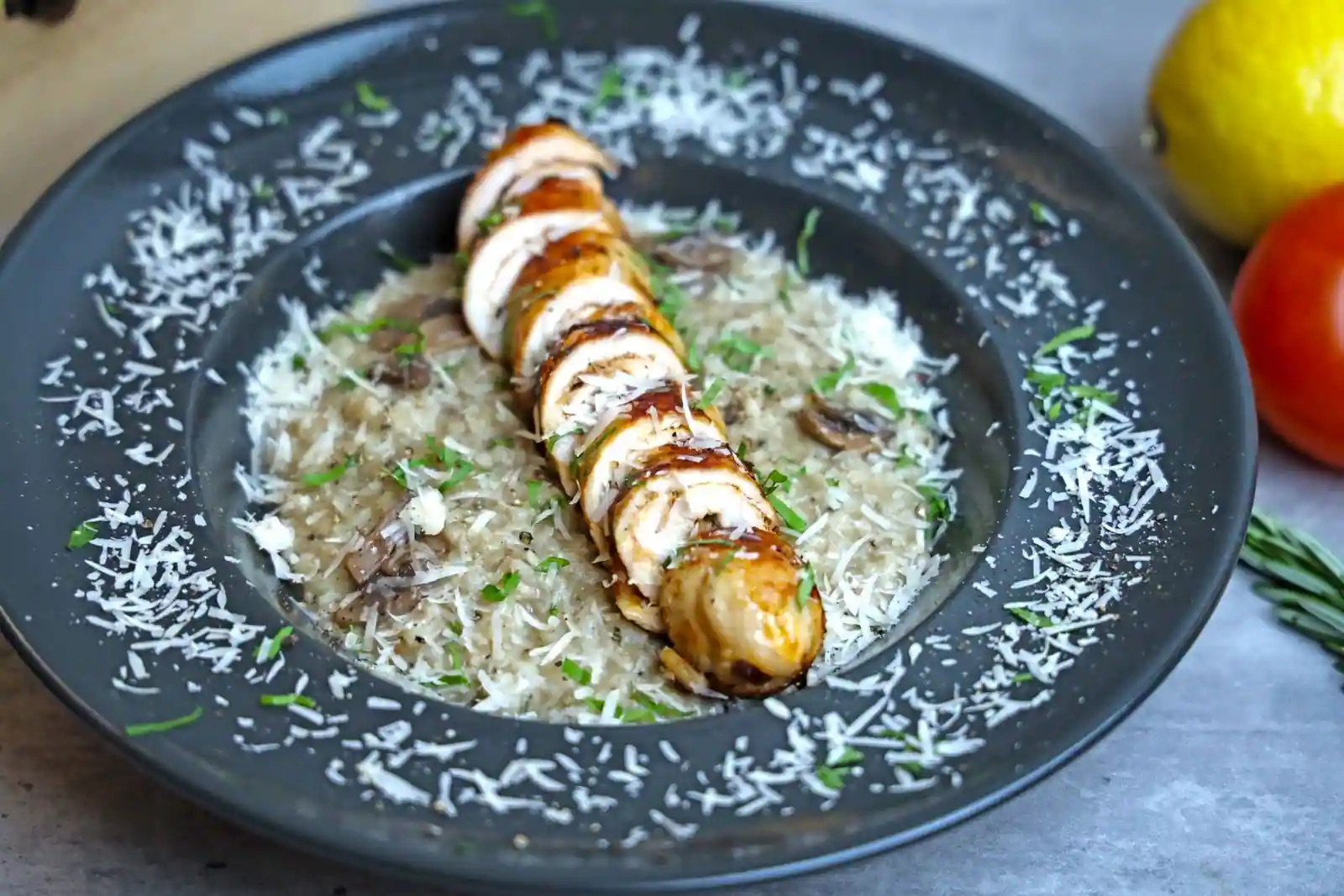 Assiette de risotto crémeux aux champignons et morceaux de poulet, parsemé de persil