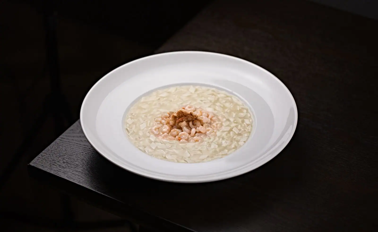 Assiette de risotto crémeux garni de petites crevettes, riz italien onctueux servi à l'assiette