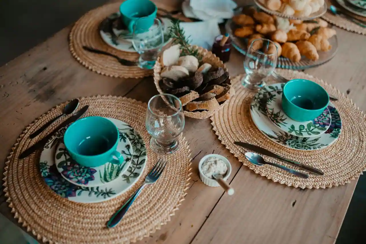 Sets de table ronds tressés sur une table en bois avec assiettes et couverts