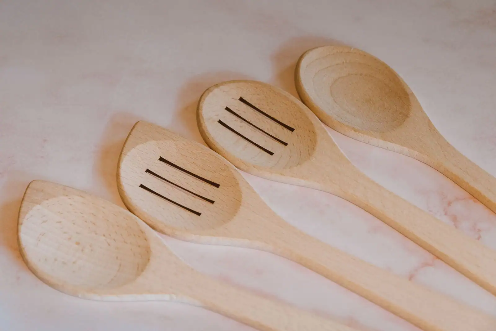 Cuillères et spatules en bois alignées sur un plan de travail clair