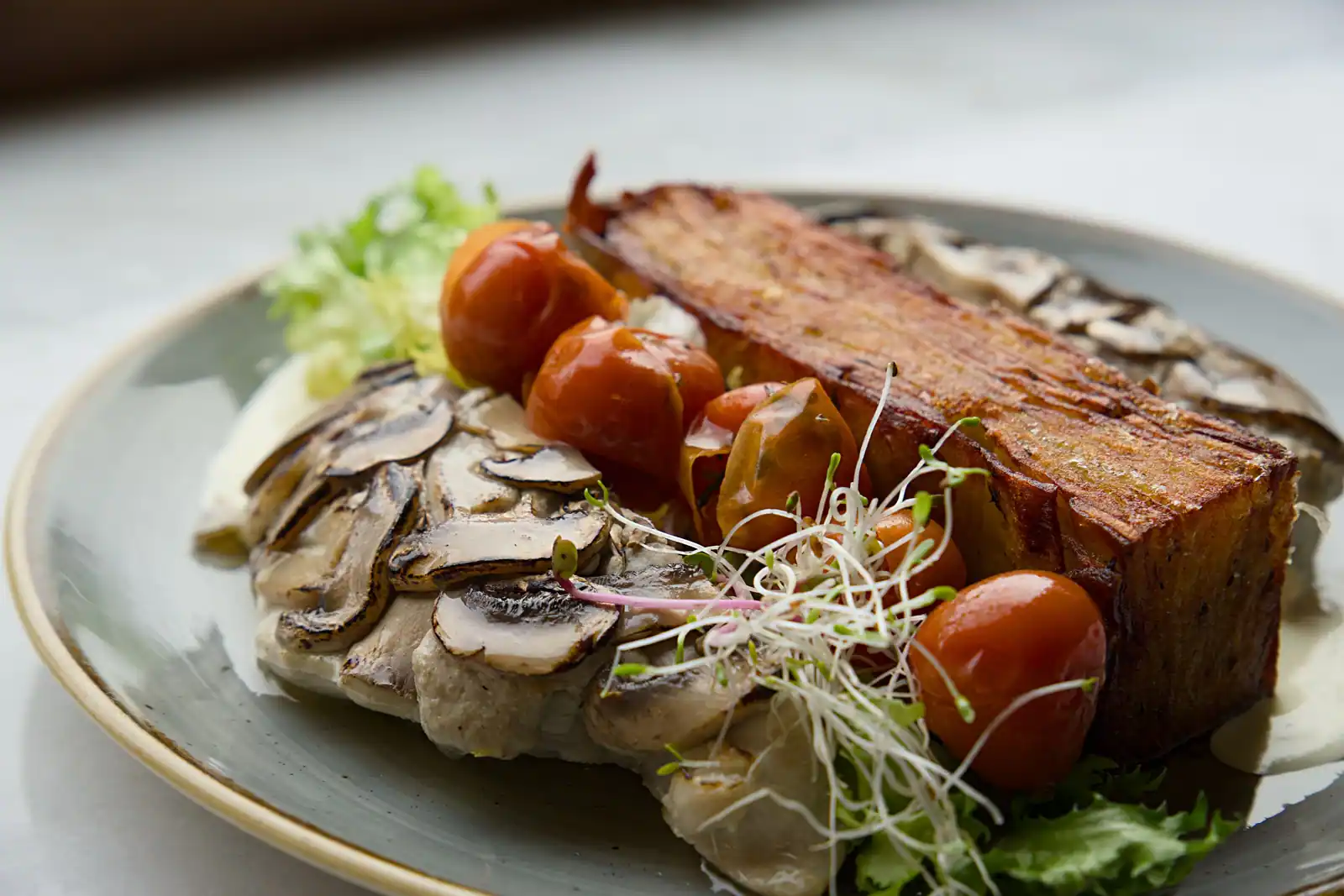 Plat végétarien gourmand aux champignons, tomates cerises et pousses fraîches, dressé pour un repas de fête.