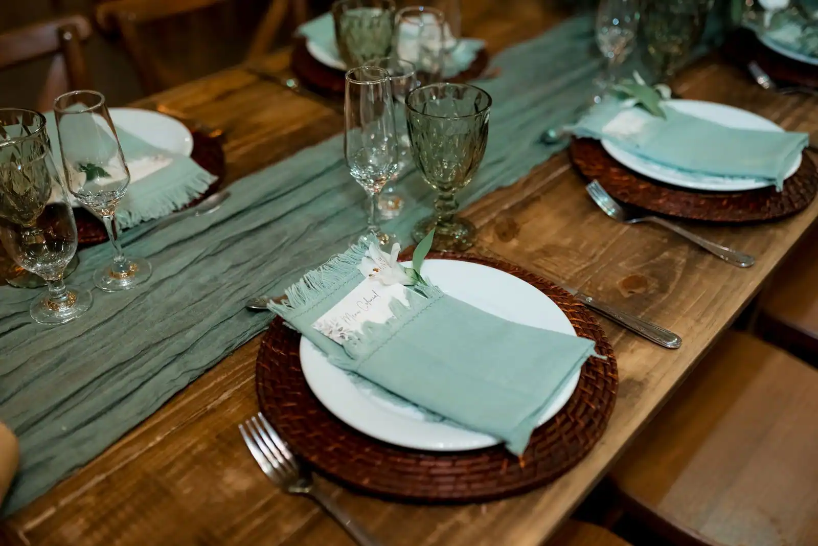 Table dressée avec des sets de table individuels, serviettes pliées et couverts disposés